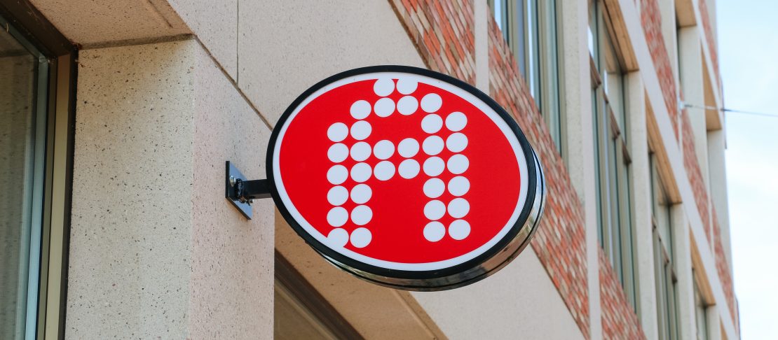 Gevelbord met het Alert-logo aan een kantoorpand in Sittard